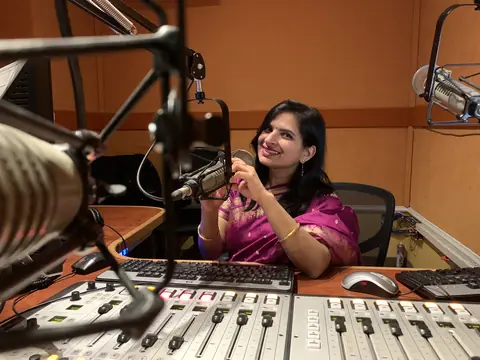 Swati in a pink sari at the studio microphone