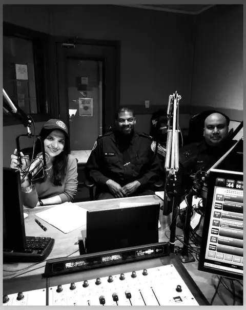 Black and white photo of Swati with guests in the studio