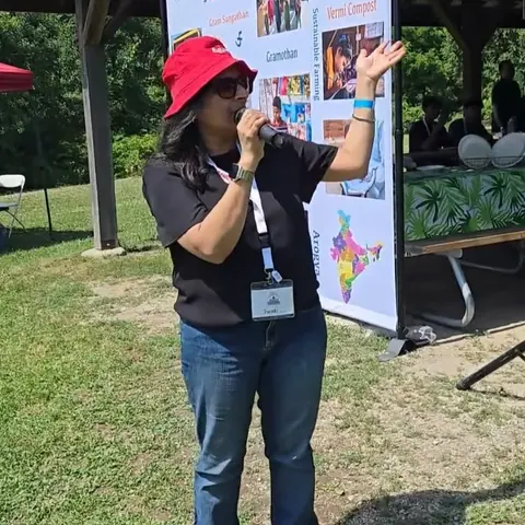 RJ Swati speaking into a microphone as MC of Ekal Picnic 2025