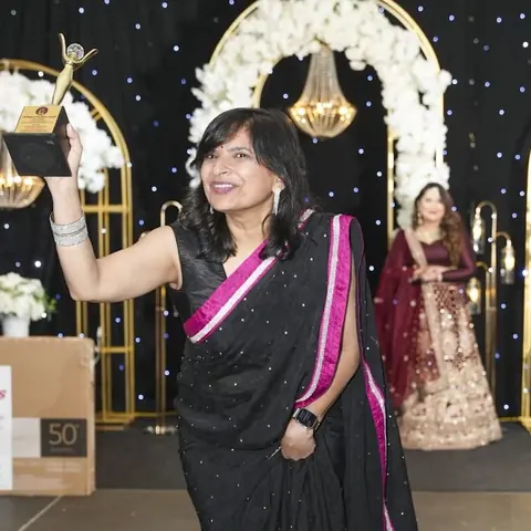 RJ Swati on stage holding up her 50 Women of Excellence Award, 2024